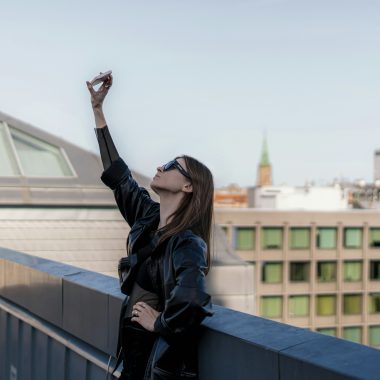 a woman standing on top of a roof with her arms in the air