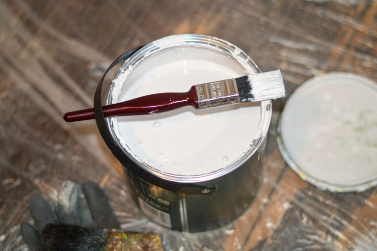 tin of white paint with brush